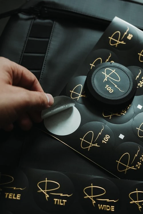 Applying a lens ID sticker to a camera lens cap